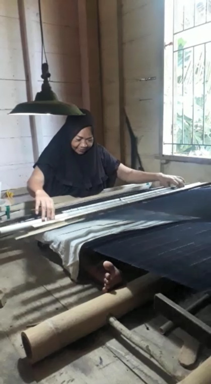 Salah seorang perempuan Ammatoa Kajang sedang melakukan aktivitas menenun (foto : Nursida)